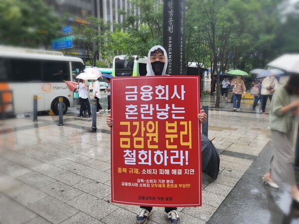 금융감독원 직원 중 한 명이 정부의 금융감독체계 개편에 반대하기 위해 여의도역에서 1인 시위를 하고 있는 모습 (사진=이코노미사이언스DB)